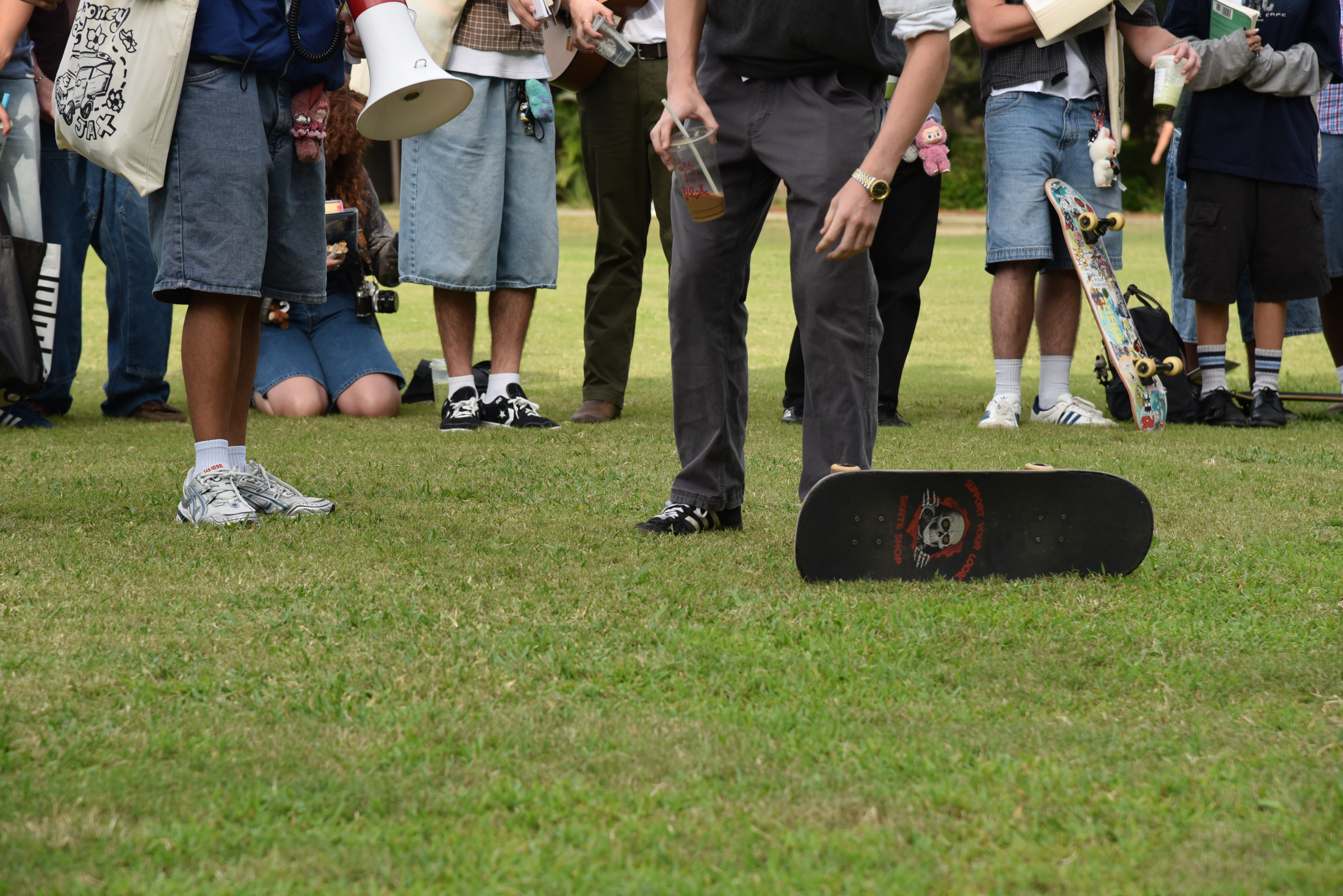 A lineup of the lower half of contestants outfits showing a row of jorts and white sneakers and matcha lattes.