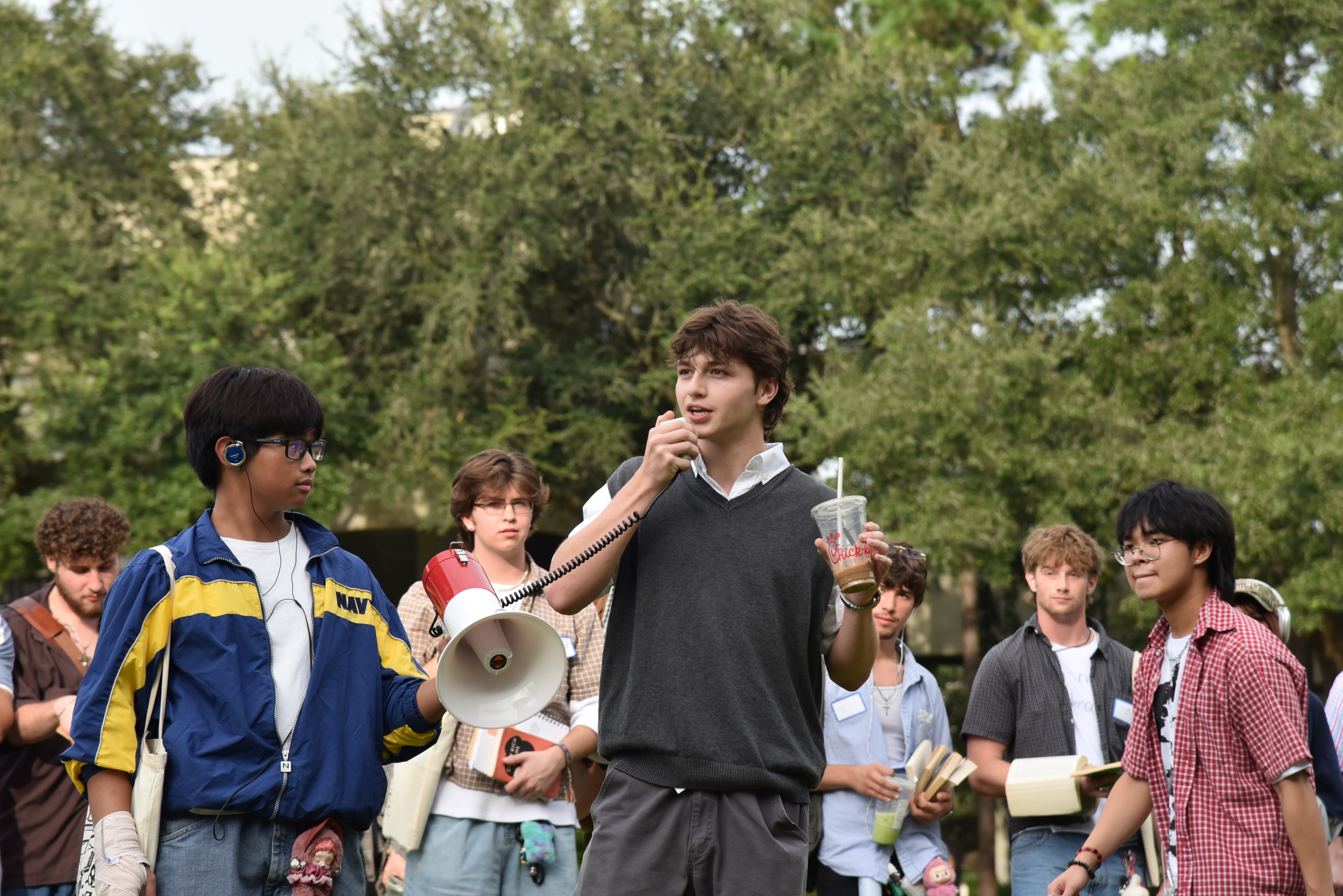 Students perform for a crowd wearing jorts, holding matcha lattes.